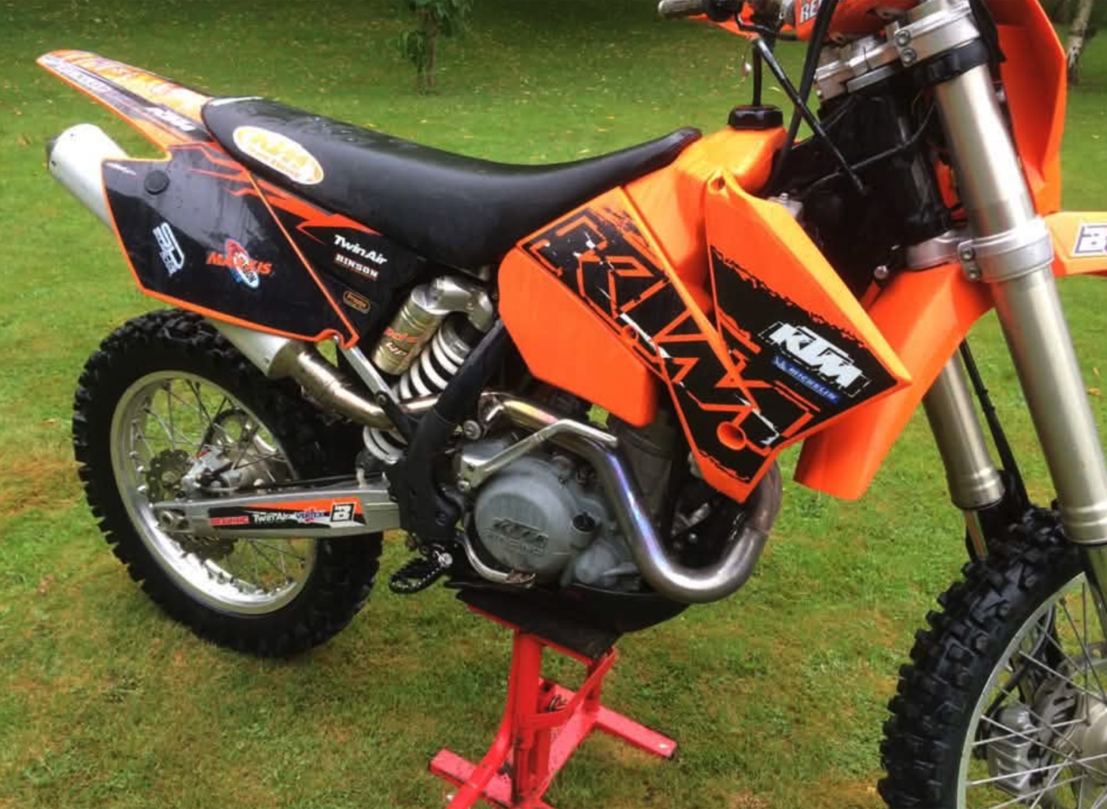 Close-up of the KTM's tank graphics, shock and engine