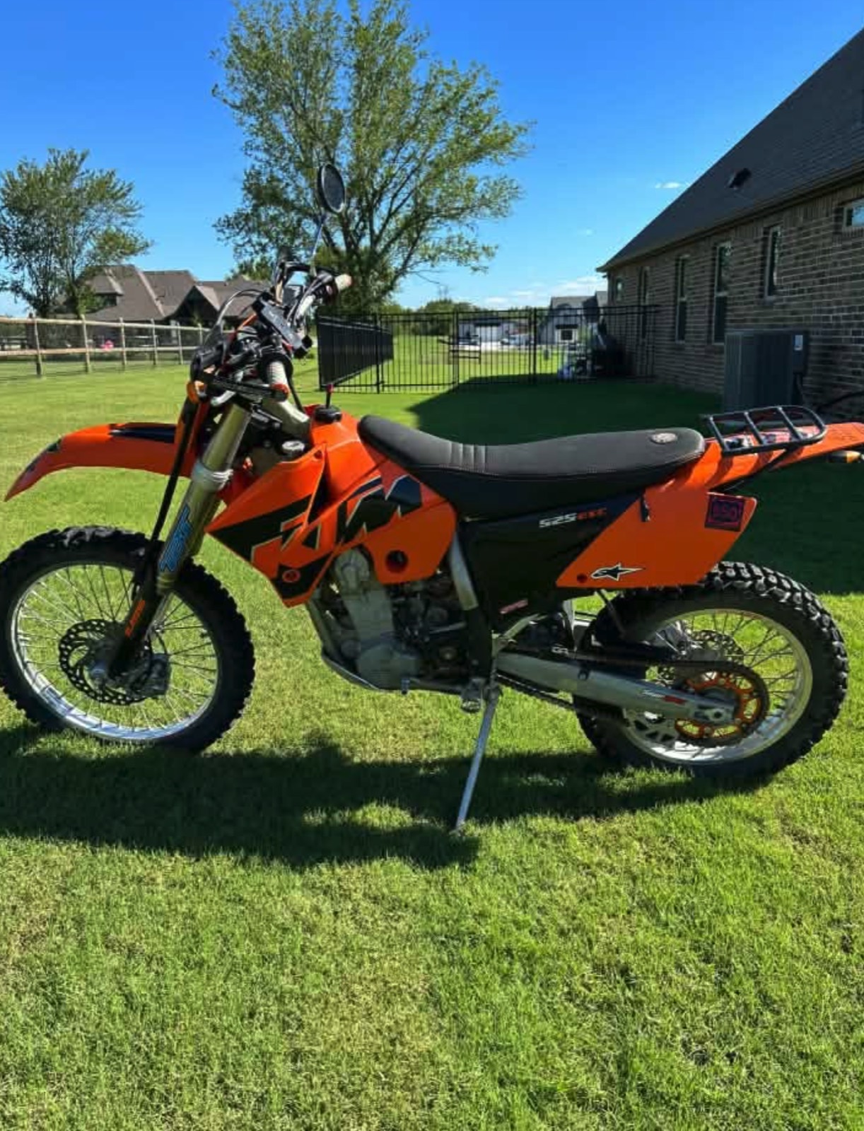 A KTM 525 EXC with a rear rack on a green lawn