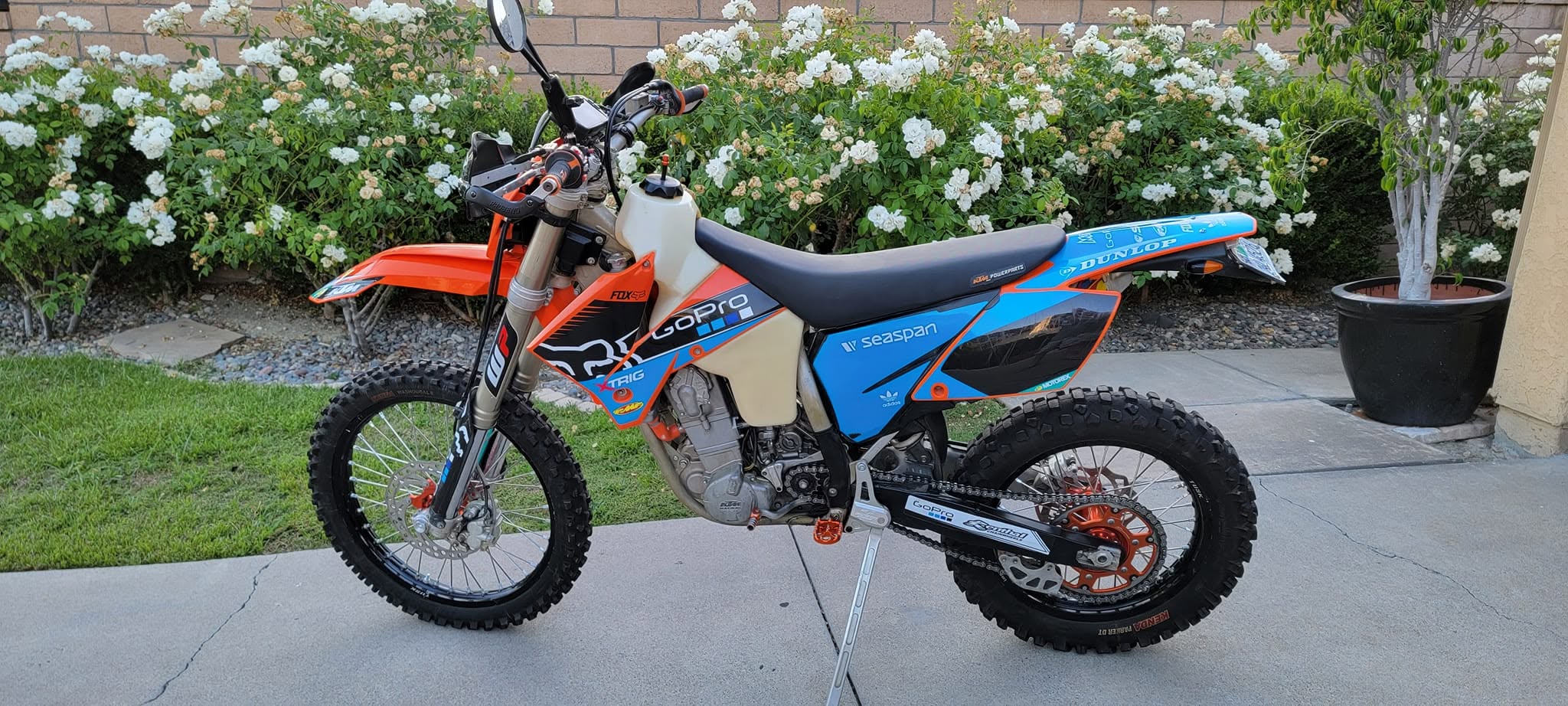 An RFS-era KTM in orange and blue graphics, ready to ride