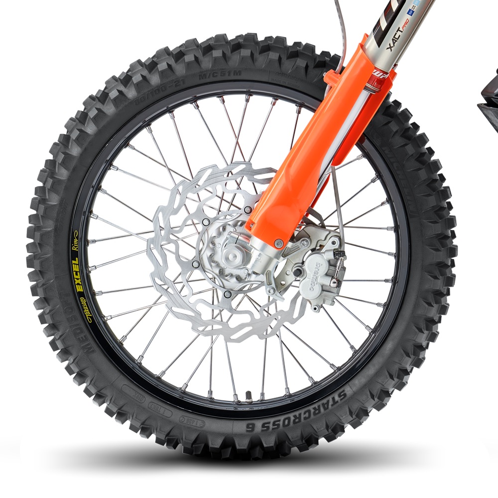 A Michelin Starcross 6 front tire on a black rim with a wave brake disc and orange fork